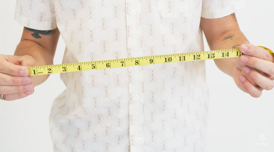 Person measuring holding yellow measuring tape on a white background